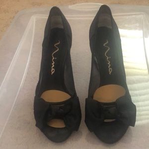 Black heels, with sheer mesh on the sides, and black bow on the open toe